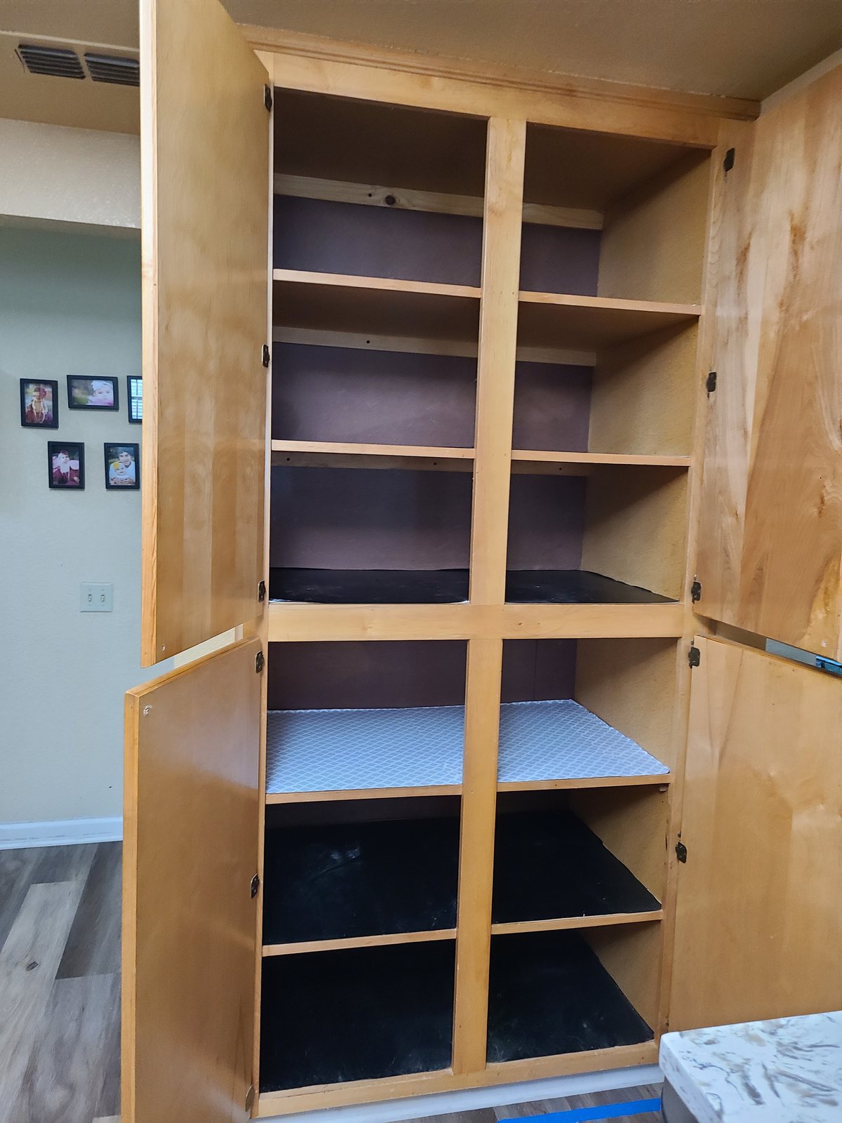 A wooden pantry cabinet with adjustable shelves