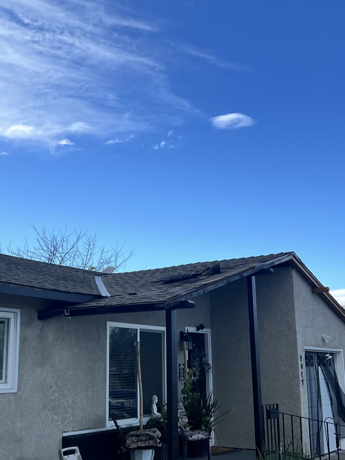 A weather-damaged roof above a home entry