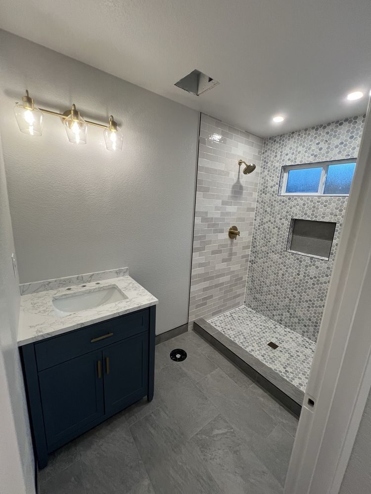 Navy vanity and a tiled walk-in shower