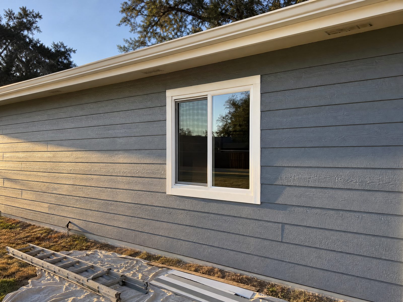 Repaired siding, trim and window on a single-story home